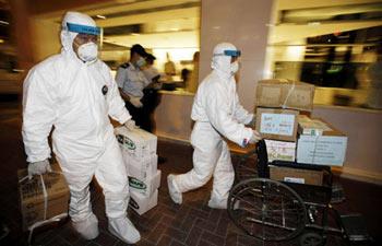 Medical workers transport boxes of disinfectants to the quarantined Metropark Hotel, where the patient of influenza A/H1N1 checked in, in Wanchai of Hong Kong, south China, May 1, 2009. (Xinhua/Zhou Lei)