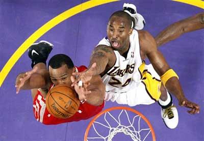Houston Rockets forward Chuck Hayes (L) grabs a rebound from Los Angeles Lakers guard Kobe Bryant during the first half of Game 7 of an NBA Western conference playoff basketball series, on Sunday in Los Angeles. The Lakers see off the Rockets by crushing their opponents 89-70 to advance to the Western Conference finals. [Photo: sina.com.cn]