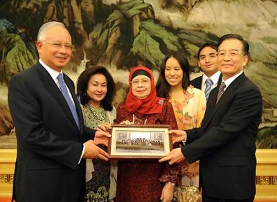 Visiting Malaysian Prime Minister Najib Tun Razak (front, L) receives a special gift, a photo of his late father and China's late Premier Zhou Enlai when the two established diplomatic ties between China and Malaysia in 1974, from Chinese Premier Wen Jiabao (front, R), in Beijing, capital of China, June 3, 2009. (Xinhua/Li Xueren)