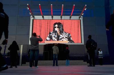 Fans take pictures of an electronic screen projecting a press conference by Michael Jackson at the O2 arena in London on March 5, 2009. The pop megastar announced he would play a series of comeback concerts in London in July, his first major shows in more than a decade.