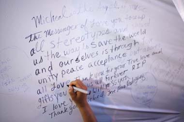 A fan writes a message on a wall following the Michael Jackson public memorial at the Apollo Theater in New York June 30, 2009. [Photo: Xinhua/Reuters]