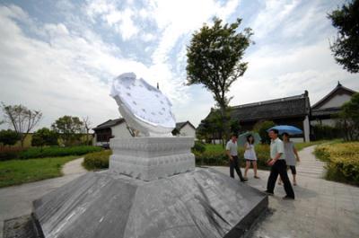 People watch the newly-installed equatorial sundial, measuring 1.5 meters in diameters, donated by the National Observatory to mark the spot for observation of the forthcoming 2009 total solar eclipse on the Yangtze Valley, believed to be the longest one visible in the century that is to betide on July 22, in Haining, east China's Zhejiang Province, July 15, 2009. (Xinhua/Wang Chaoying)