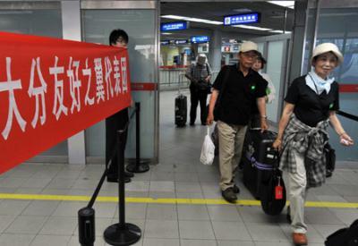 Residents of Japanese city of Oita walk out of the Tianhe Airport in Wuhan City, central China's Hubei Province, July 18, 2009. A delegation, consisting of some 160 Oita citizens, arrived in Wuhan for their planned observation of the longest total solar eclipse of the 21st century, set to occur on July 22 over China.(Xinhua/Zhou Chao)