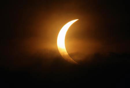 The moon passes between the sun and the earth amid monsoon clouds during a solar eclipse in New Delhi on July 22, 2009. (Xinhua/Reuters Photo)