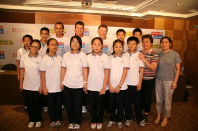 John Shiels, CEO of the Manchester United Foundation, and soccer stars Dimitar Berbatov and Michael  Carrick (third to fifth from the right, back) pose for photos with children and teachers involved in the "Skills for Life in a Box" project in Hangzhou, eastern China's Zhejiang Province, on July 25, 2009. [Photo: CRIENGLISH.com]