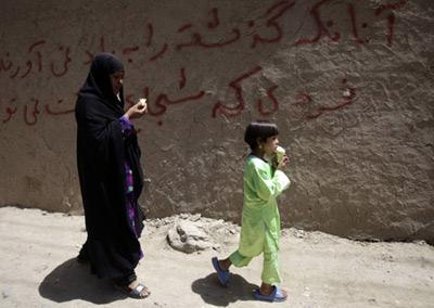 An Afghan woman and girl eat ice cream as they walk down the street in Kabul, August 6, 2009. (Xinhua/Reuters Photo)