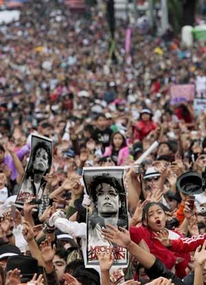 Michael Jackson fans hold up his poster as they dance to "Thriller" in celebration of the late singer's 51st birthday in Mexico City August 29, 2009. Over 12,000 fans danced to Michael Jackson's "Thriller" at the event, breaking a Guinness world record.(Xinhua/Reuters Photo)