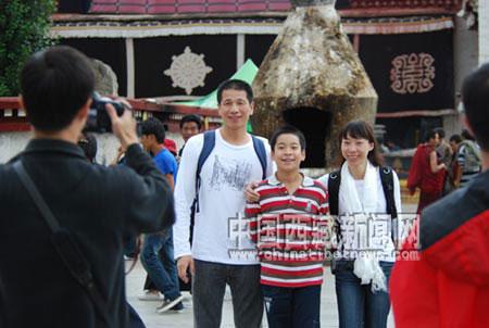 A man takes a photo for three tourists on the square of the Jokhang Temple, Lhasa, capital of southwest China's Tibet Autonomous Region, Sept. 11. 2009. (Photo Source: chinatibetnews.com)