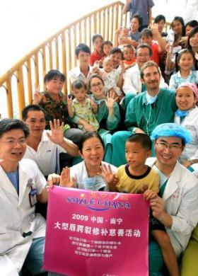 Children with cleft palate who are about to undergo plastic surgeries pose for a group photo with their parents and doctors in Nanning, southwest China's Guangxi Zhuang Autonomous Region, on Sept. 17, 2009. Twenty plastic surgeons from home and abroad began their visit in Nanning on Thursday to perform plastic surgeries for 100 local children with cleft palate during the medical charity project "Smile China". Founded in 2001 by Canada-born Chinese plastic surgeon Joseph K. Wong, the project has been offering free treatment around China to children whose families are too poor to afford the operation. Thanks to the project, about 600 children underwent corrective surgeries for free in China up to now. (Xinhua/Chen Fei)