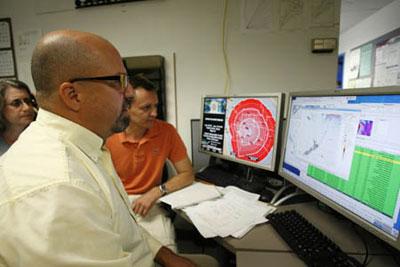 Christopher Moore (L) and Visily Titov of NOAA look at computer graphs at the Pacific Tsunami Warning Center in Ewa Beach, Hawaii, concerning the earthquake and tsunami that hit American Samoa September 29, 2009.(Xinhua/Reuters Photo)