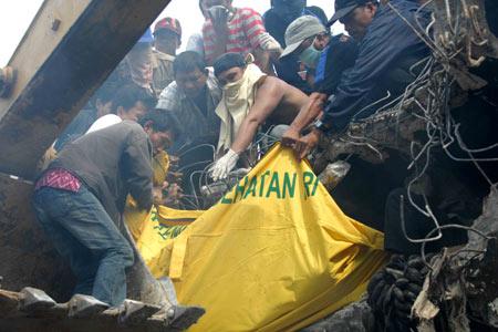 Rescuers carry a victim's body in the Sumatran city of Padang, Indonesia, on Oct. 2, 2009. 1,100 people were killed in a powerful earthquake Wednesday evening and the number could rise to thousands as many people were still trapped in the debris. (Xinhua/Yue Yuewei)