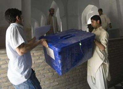 Afghan men carry a box of election materials at a polling station in Jamee Mosque in Herat, western Afghanistan August 19, 2009. Afghanistan has ordered Western and domestic media to impose a blackout on coverage of violence during Thursday's polls, saying it did not want Afghans to be frightened away. President Hamid Karzai is running against 30 challengers and faces a second-round run-off against the next best contender if he does not secure more than 50 percent of the vote on Thursday.REUTERS/Raheb Homavandi