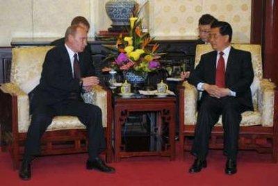 Russian Prime Minister Vladimir Putin (L) talks with Chinese President Hu Jintao (R) at the Diaoyutai State Guesthouse in Beijing October 14, 2009. China and Russia signed a pact to notify each other of ballistic missile launch plans during Putin's visit this week to Beijing, Chinese media said on Wednesday.REUTERS/Kyodo/Kota Kyogoku