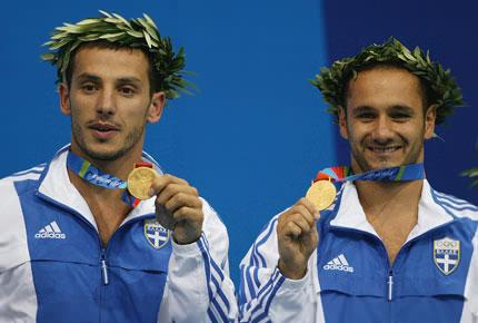 Athens, 16 August 2004, Games of the XXVIII Olympiad. Thomas BIMIS (R) and Nikolaos SIRANIDIS of Greece pose with their gold medals for the men's synchronised diving springboard event at the Olympic Aquatic Centre. Credit : Getty Images/Daniel Berehulak