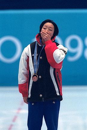 Nagano, 19 February 1998, XVIII Olympic Winter Games. Women's short track speed skating 500m: CHUN Lee-Kyung of Korea, 3rd, is moved during the medals ceremony. Credit: Getty Images/DUNN Stephen