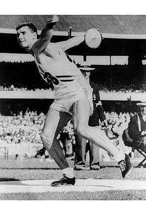 1956, Melbourne: American discus thrower Al OERTER on route to winning his first Olympic discus title. Competing at the Games of the Olympiad between 1956 and 1968, OERTER won each of his four medals with an Olympic record setting throw. Credit: Getty Images