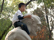 一名小遊客爬上雕像拍照留念