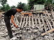 都江村村民在自家跨塌的房屋前