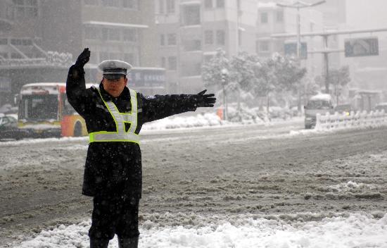 一名杭州交警在路口冒雪指揮交通