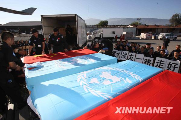 Chinese rescuers mourn as bodies of buried Chinese peacekeepers in Haiti are retrieved from ruins, in Port-au-Prince on January 16, 2010. Huang Jianfa, chief of the Chinese rescue team, said to Xinhua that all eight buried Chinese staff were confirmed dead.