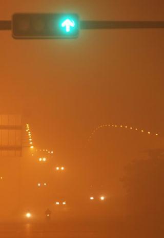 Vehicles move with headlights on in heavy fog at about 10 pm on January 28, 2010 in Foshan city, south China's Guangdong province.[Photo/CFP]