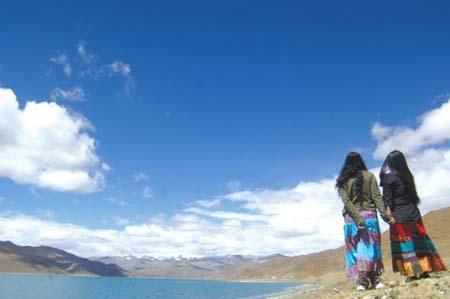 An undated photo shows two visitors doing sightseeing by the Yamdrok Yumtso Lake in Shannan Prefecture, southeastern Tibet.[Photo: Lhasa Evening News] 