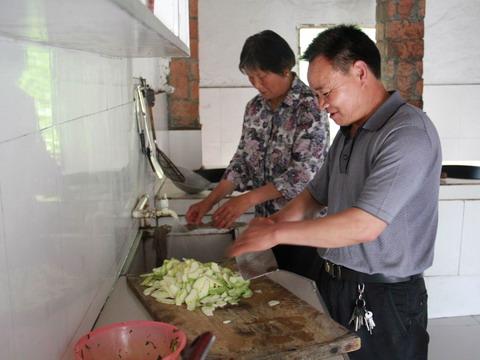 夫妻二人共同為住宿學生做晚飯。