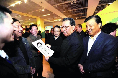 3月16日，中共中央政治局常委李長春來到中國國家博物館，參觀正在這裡舉行的黨的十七大以來中國動漫産業發展成果展。這是參展工作人員向李長春贈送動漫肖像畫。新華社記者 李 濤 攝