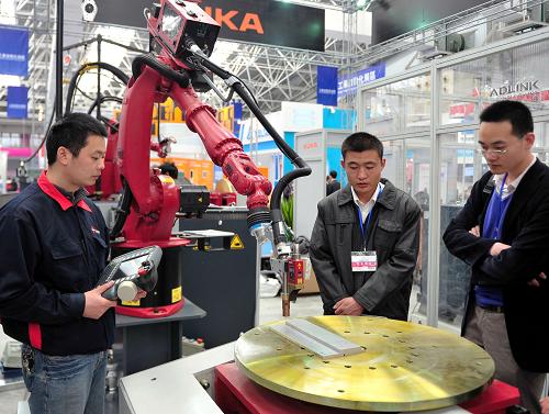 3月29日，一台機器人在首屆中國國際進口産品博覽會上對工業品實施激光跟蹤作業演示。當日，首屆中國國際進口産品博覽會在江蘇省昆山市開幕，來自美國、加拿大、日本、德國等46個國家和地區的600余家企業參展，其中21家世界500強企業帶來了一流的技術和産品，十多臺工業機器人成為博覽會亮點。 