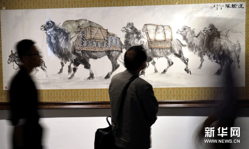 參觀者在欣賞黃胄的作品《運輸隊圖》。