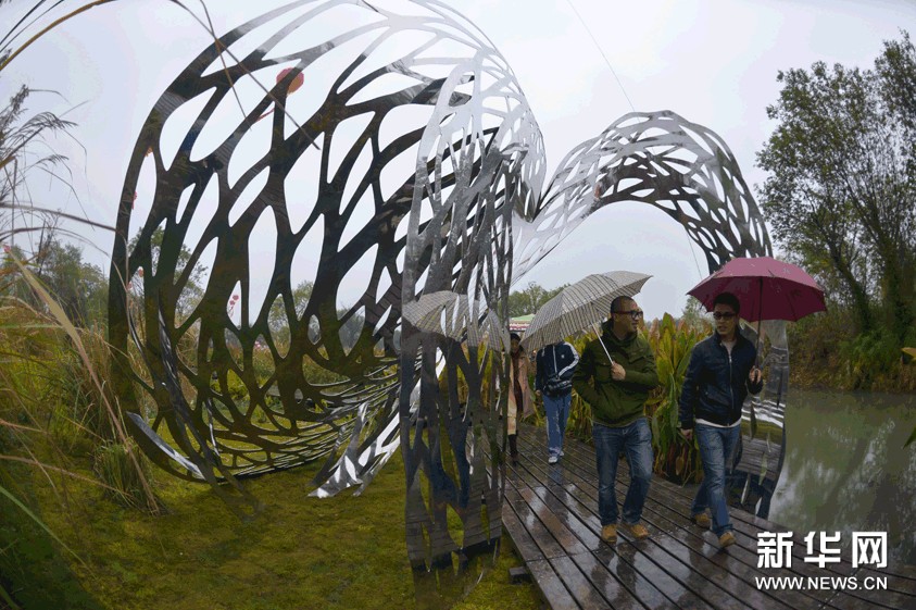 遊人從一件名為“風”的雕塑旁通過。藝術家用不銹鋼的材質來表現吹過濕地的風的形態（11月23日攝）。