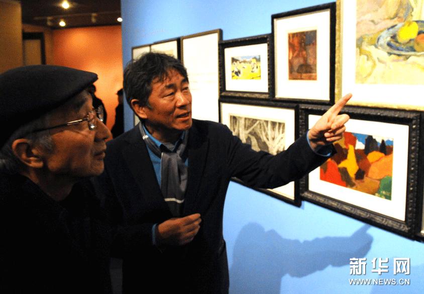12月7日，譚平（右）在介紹自己的繪畫作品。