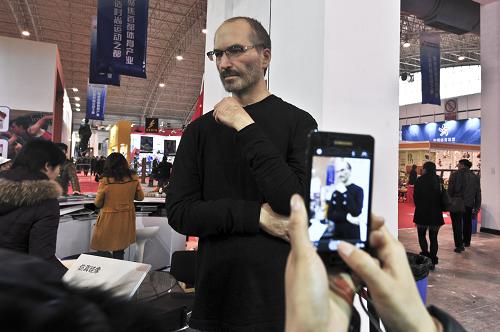 12月20日，一名參觀者在第七屆中國北京國際文化創意産業博覽會上拍攝高倣硅像《喬布斯》。新華社發（王振 攝）