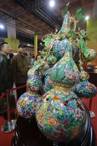12月20日，在第七屆中國北京國際文化創意産業博覽會上，觀眾在欣賞景泰藍作品《福祿萬代》。新華社發（王振 攝）