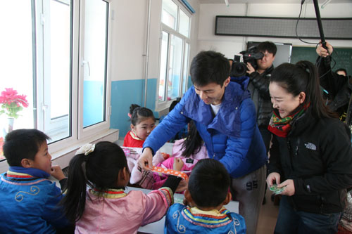 主持人徐柳和趙一天把少兒頻道啪啪圈戴到學生們的手腕上