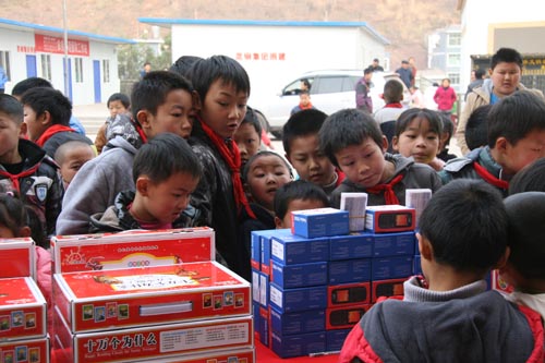 雲南昭通彝良毛坪小學的同學們熱烈圍觀愛心捐贈的圖書和手機