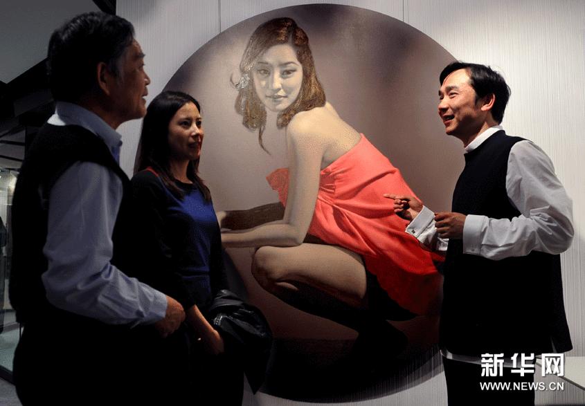 3月7日，藝術家侯慶（右）向觀眾介紹自己的繪畫作品。