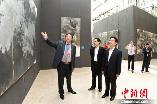 中國文化建設協會副會長官景輝（右）在王林旭的陪同下參觀“中國文化走向世界”王林旭當代藝術展。