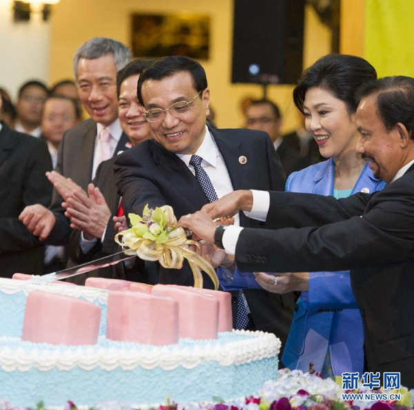 資料圖片：10月9日，李克強在文萊首都斯裏巴加灣市出席第16次中國－東盟（10＋1）領導人會議。這是會議開幕前，李克強與文萊蘇丹哈桑納爾、泰國總理英拉出席“紀念中國－東盟建立戰略夥伴關係10週年”切蛋糕儀式。 新華社記者 黃敬文 攝