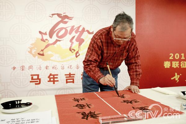 中國書法家協會副主席胡抗美先生在“書寫大會”上書寫春聯。馬也 攝