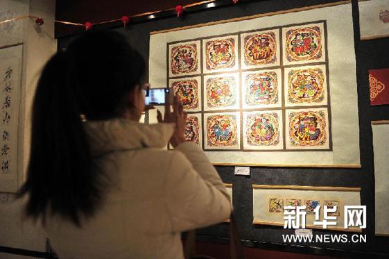    2月7日，拉薩市民在用手機拍攝展出的年畫。新華網圖片 劉坤 攝