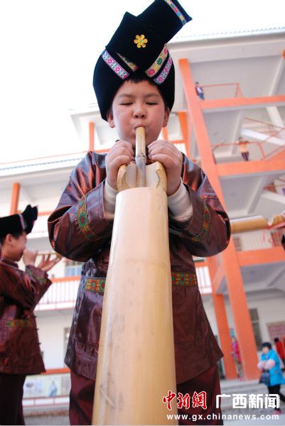 三江縣林溪小學的一名男生在吹蘆笙