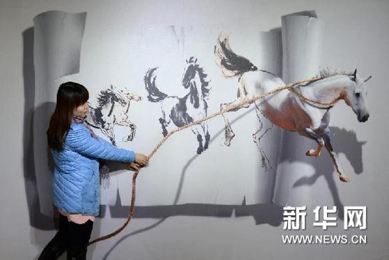   2月25日，在河北承德展出的3D魔幻藝術展上，觀眾與3D藝術畫合影。新華網圖片 王曉 攝