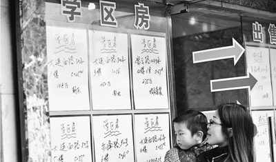 圖為上海一位家長帶著孩子在仲介門口看“學區房”房源。沈春琛攝（人民視覺）