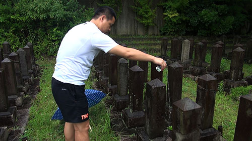 在雨中祭拜清人“李金國”。