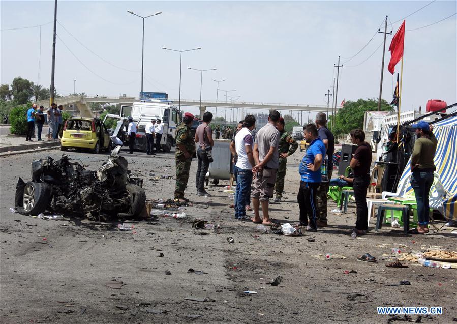  People gather at the site of a suicide car bomb explosion in Iraq