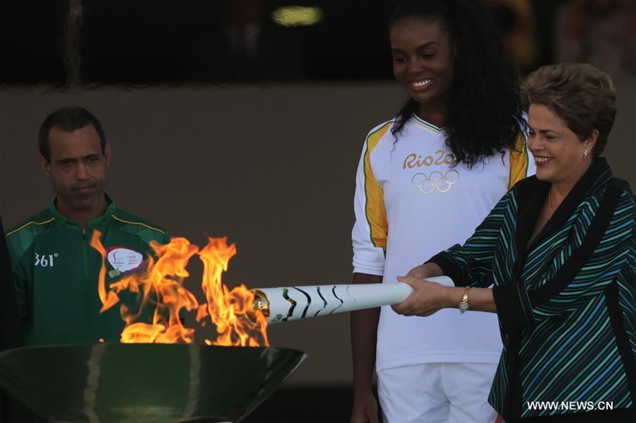 BRASILIA, May 4, 2016 (Xinhua) -- Brazilian President Dilma Rousseff lights the Olympic torch at the Planalto Palace in Brasilia May 3, 2016. Brazil on Tuesday started the 95-day Olympic torch relay which will end at the Maracana Stadium in Rio de Janeiro in August for the 2016 Olympic Games opening ceremony. (Xinhua/Rahel Patrasso)