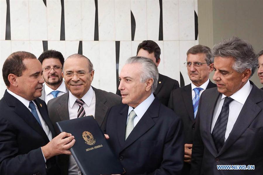 BRASILIA, May 12, 2016 (Xinhua) -- Brazilian Vice President Michel Temer(C), holds the Senate notice promoting him to acting president in Brasilia, capital of Brazil, on May 12, 2016. The Brazilian Senate Thursday voted to continue the impeachment process against President Dilma Rousseff, suspending her from office for 180 days. (Xinhua/AGENCIA ESTADO)