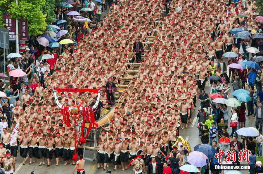 Photo shows 1,600 strong men carrying a giant wooden dragon boat to the river in Shibing County of southwest China