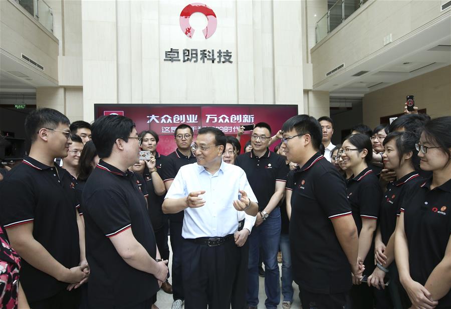 Chinese Premier Li Keqiang talks with employees of Troila Technology during an inspection tour in Tianjin, north China, June 26, 2016. (Xinhua/Pang Xinglei)